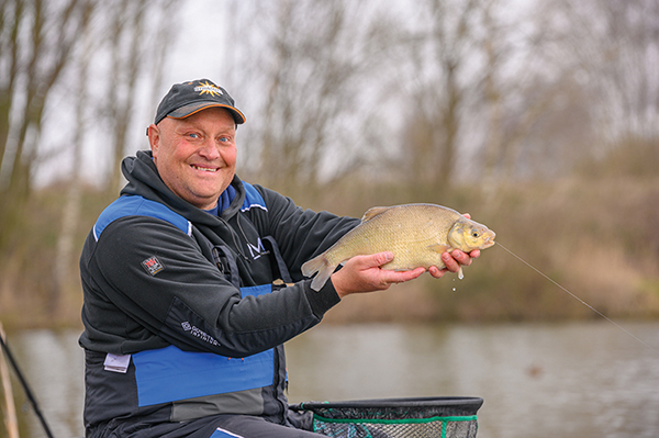 Crucian Fish Caught on Bait by the Lake, Hanging on a Hook on a